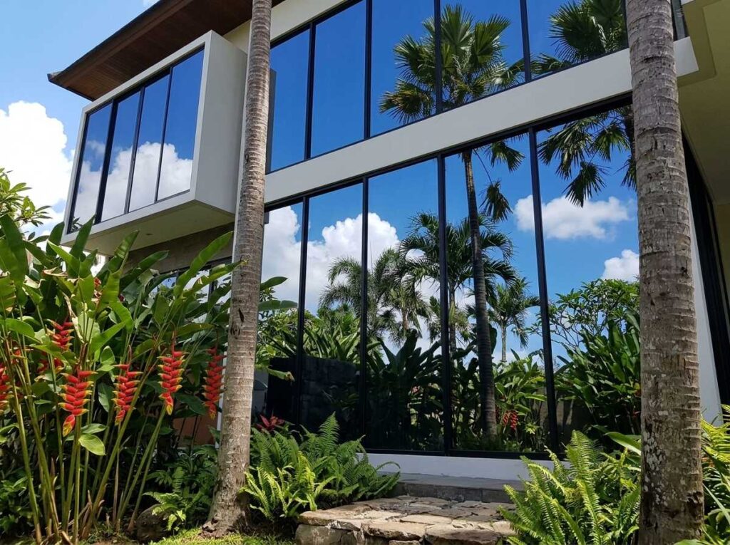 Tampilan luar kaca film rumah one way dengan efek cermin privasi siang hari di Bali.