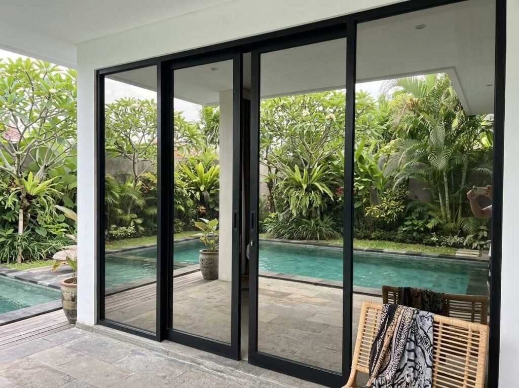 Pengaplikasian kaca film gedung untuk villa komersial pada pintu kaca sliding di Bali.